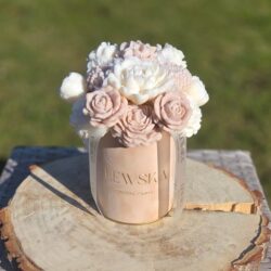 Flowerbox rozmiar M z kwiatami z wosku sojowego w welurowym pudełku koloru bordo. Kwiaty białe- beżowe mini pąki, goździki, piwonie, róże i bratek. Sylikonowa wstążka ze złotym logo Lewska
