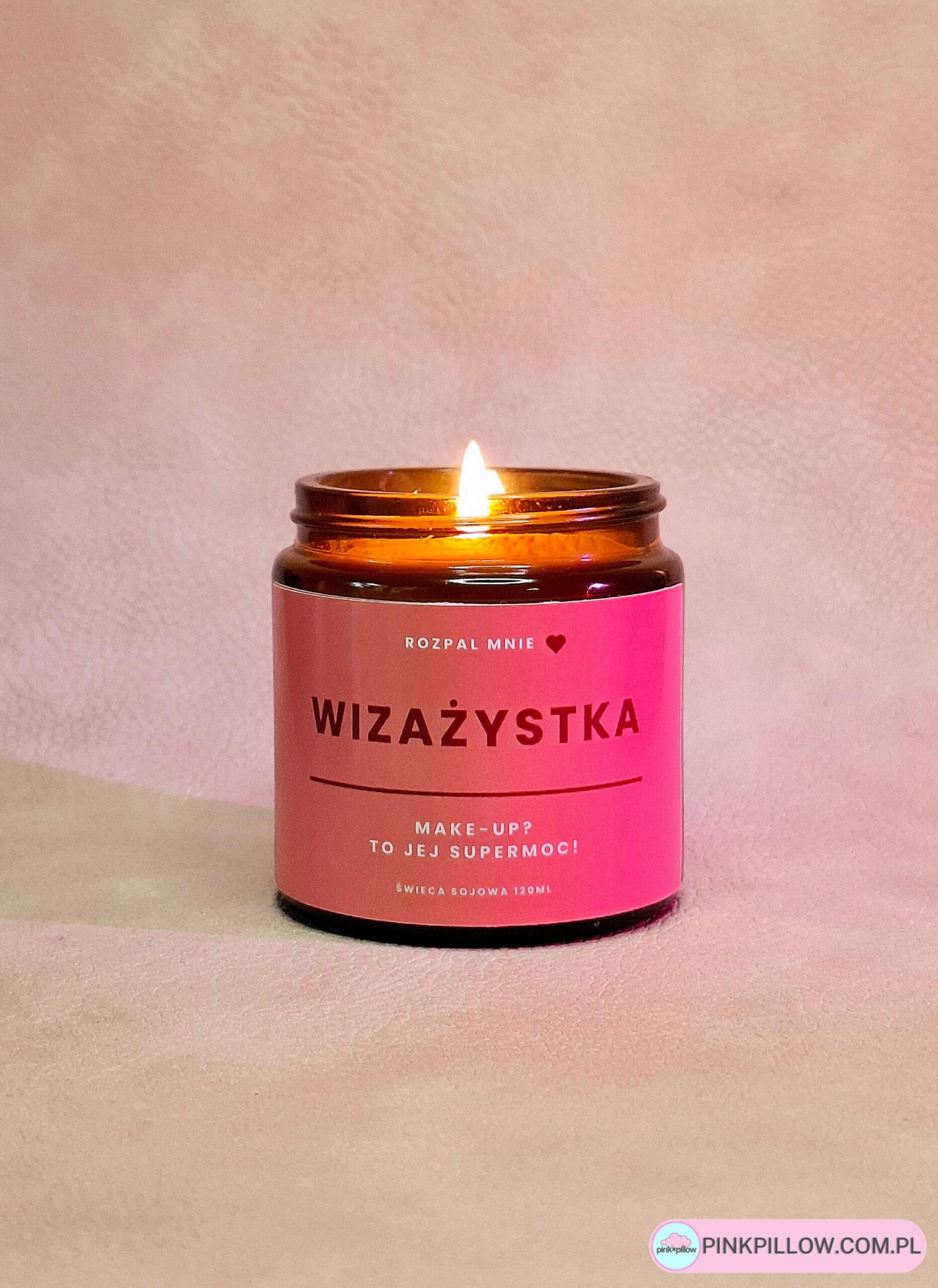 Świeczka w brązowym szkle z napisem na etykiecie wizażystka.