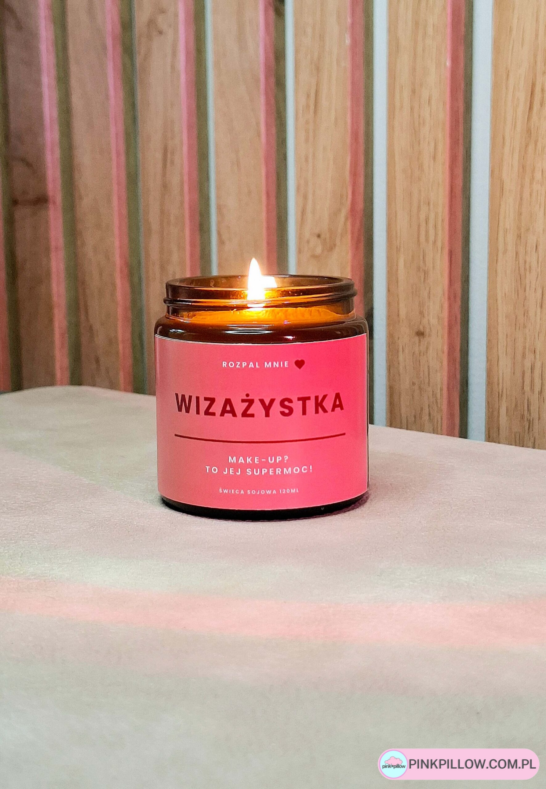 Rozpalona świeczka wizażystka na tle drewnianych paneli